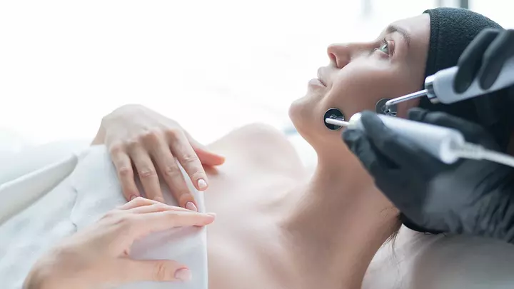 A beautiful woman having a microcurrent facial in a clinical setting